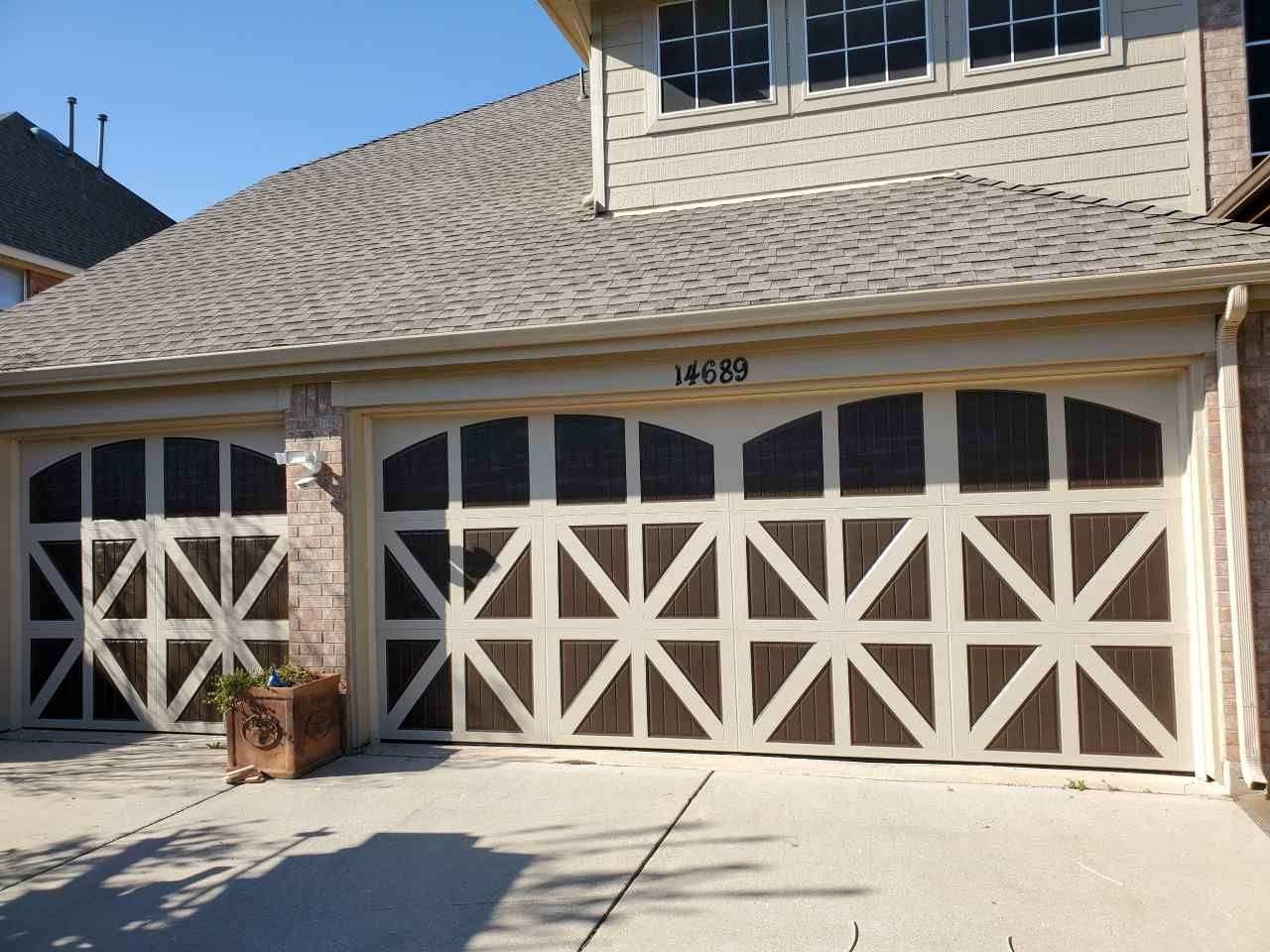 A large house with two garage doors and a roof