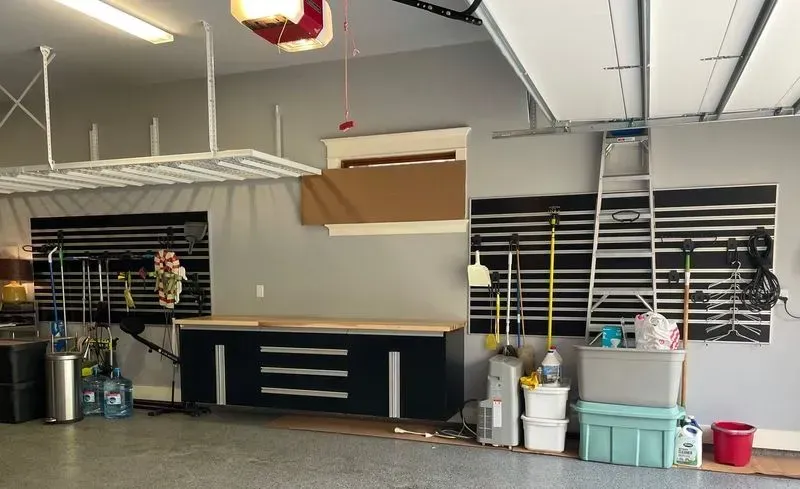 A garage with a table , boxes , and a ladder.