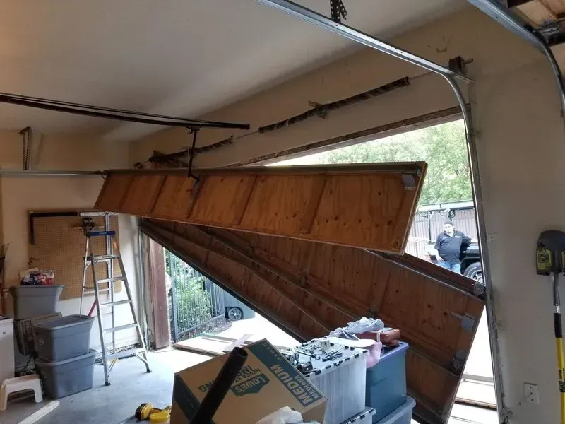 A garage with a broken garage door and boxes in it