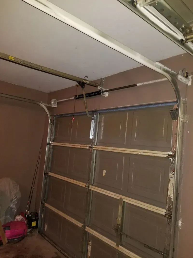 A garage door is open and sitting in a garage.