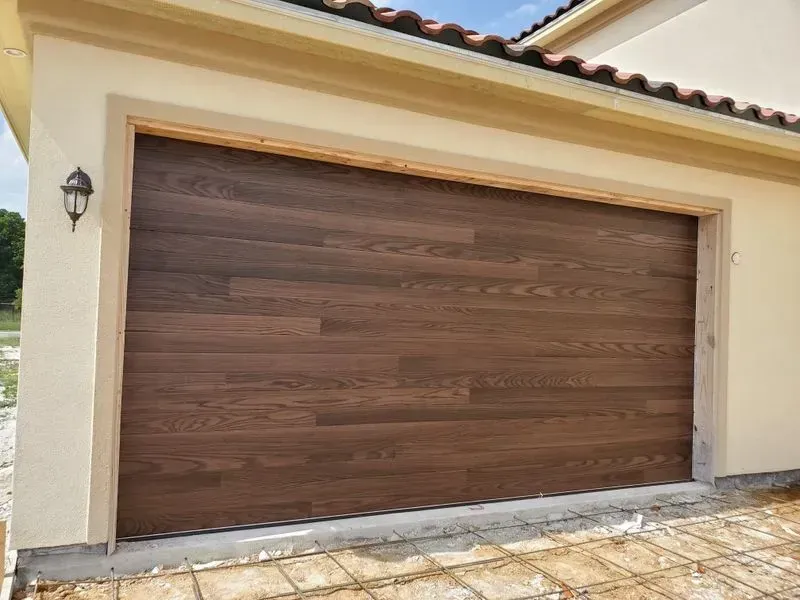 A wooden garage door is sitting on the side of a house.
