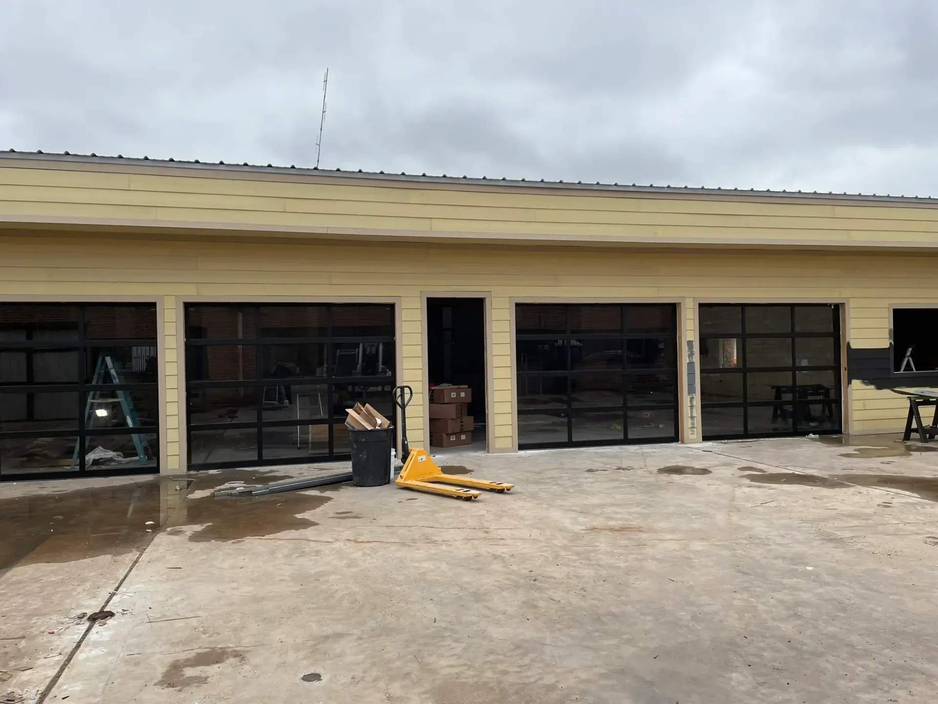 A building with a lot of garage doors is under construction.
