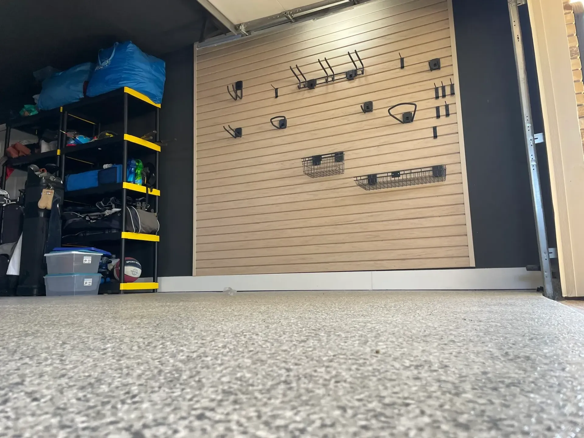 A garage with a peg board on the wall and a carpeted floor.