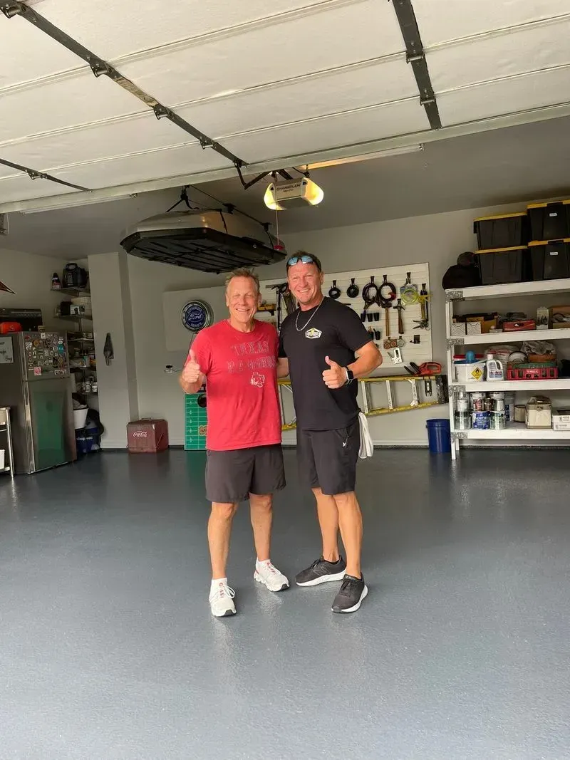 Two men are standing next to each other in a garage.