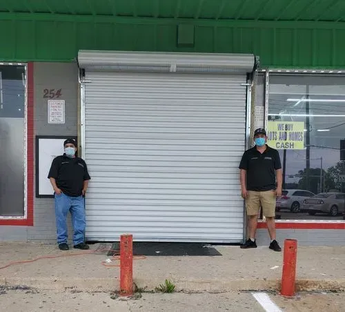 Two men wearing masks are standing in front of a store.