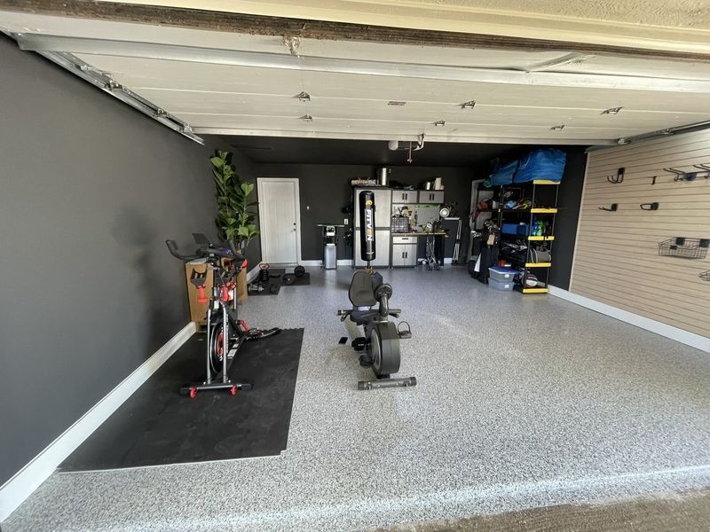 A garage with a bicycle and a bench in it.