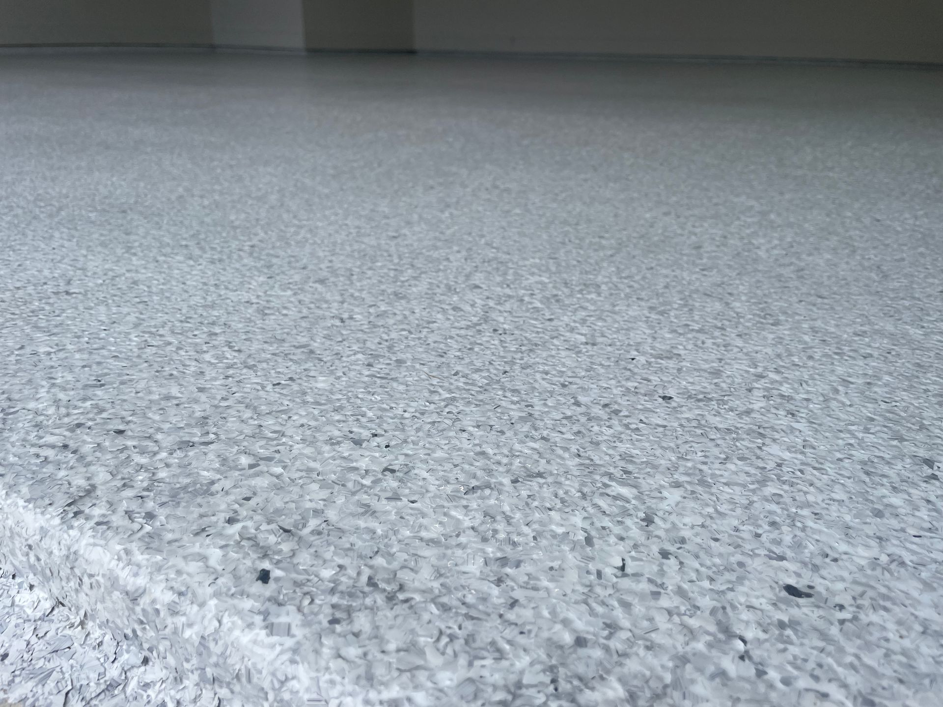 A close up of a gray carpeted floor in a room.