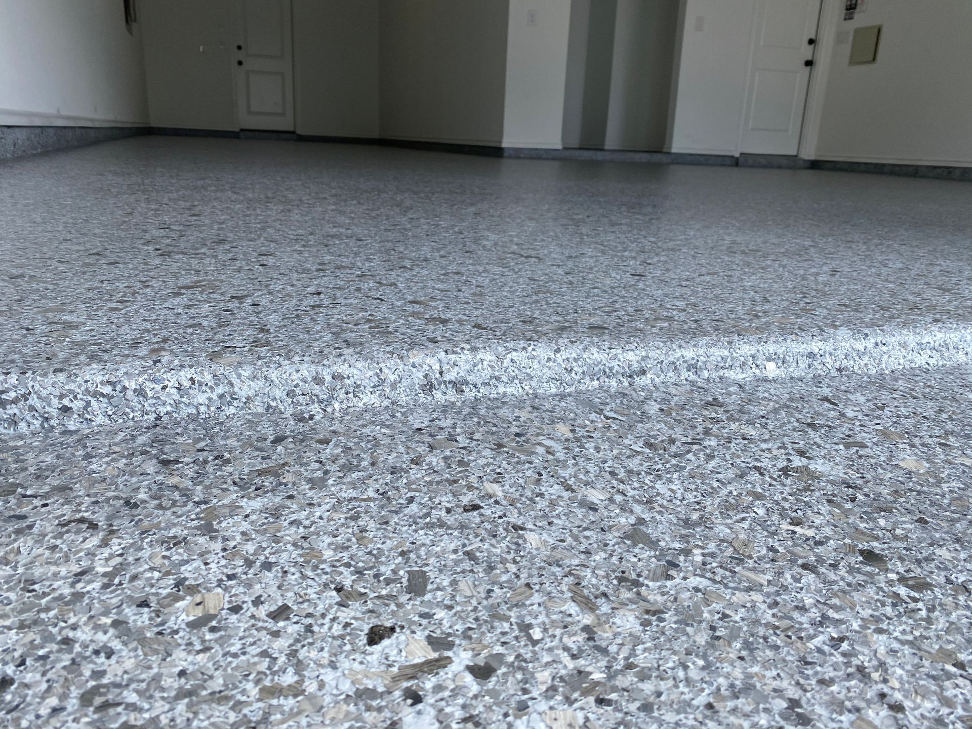 A close up of a garage floor with a white line on it.