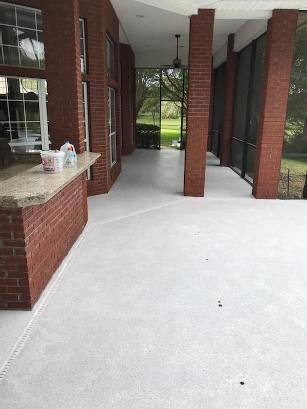 A screened in porch with a brick wall and a white floor