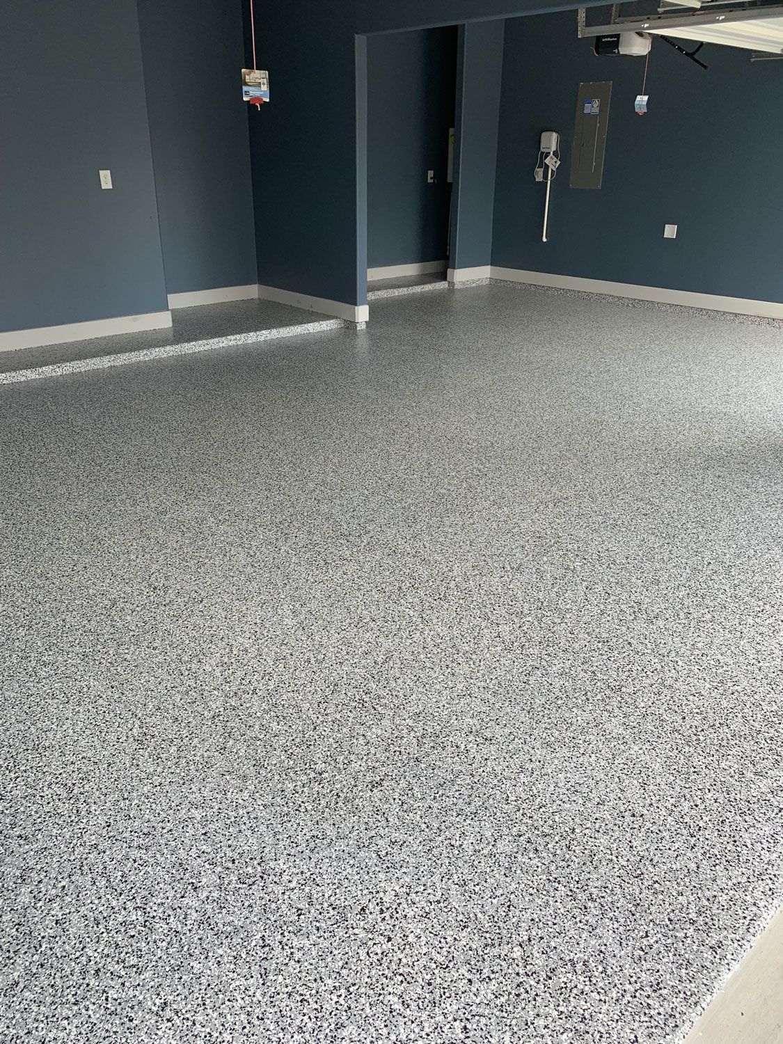 A garage with a gray floor and blue walls.
