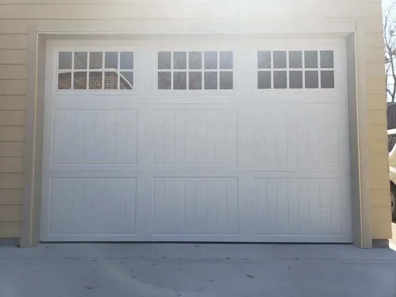 A white garage door with a lot of windows on it