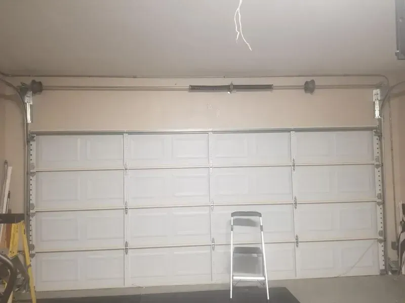 There is a ladder in the garage next to the garage door.