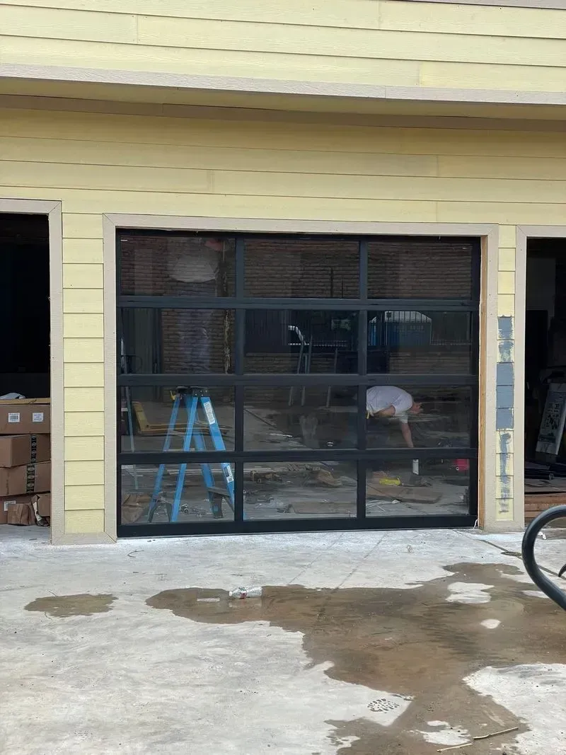 A man is standing in front of a garage door that is being installed.