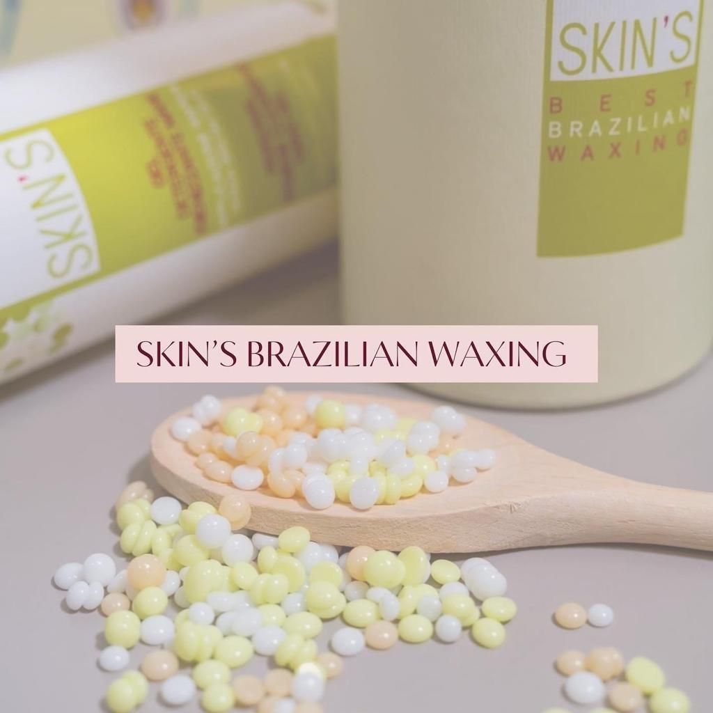 Skin's Brazilian waxing products with pastel wax beads on a wooden spoon