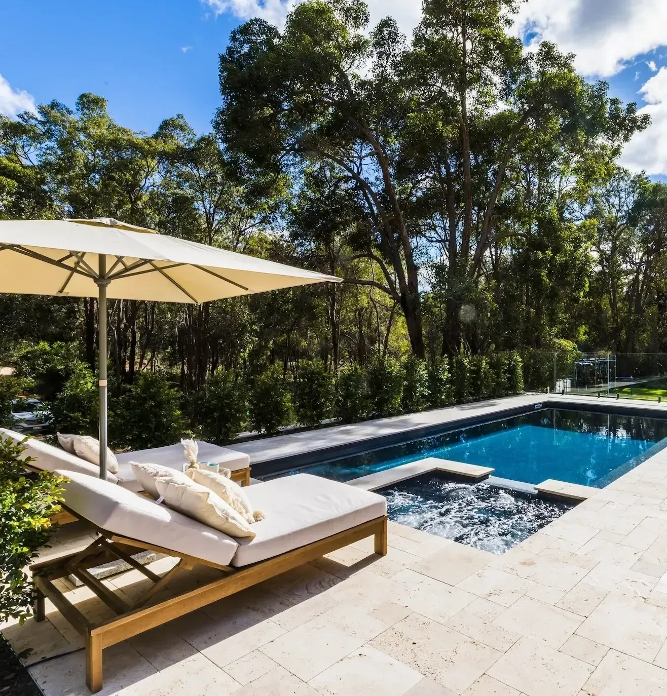 A swimming pool with an umbrella and lounge chairs