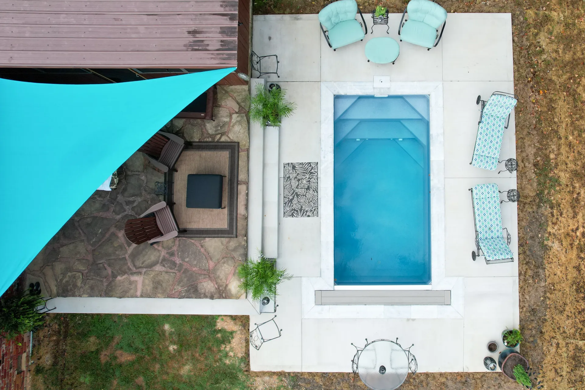 An aerial view of a swimming pool surrounded by chairs and umbrellas.