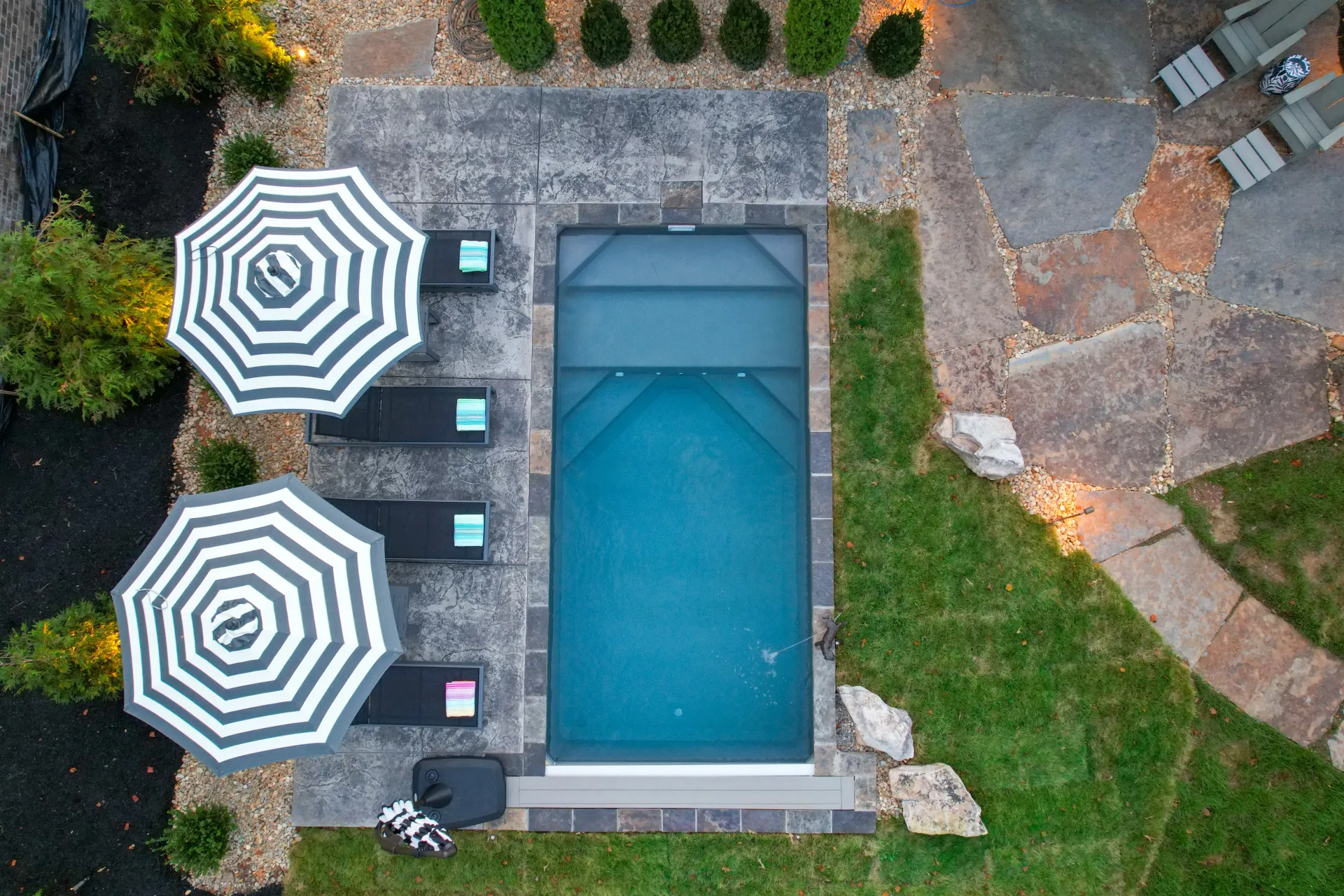 An aerial view of a swimming pool surrounded by chairs and umbrellas.