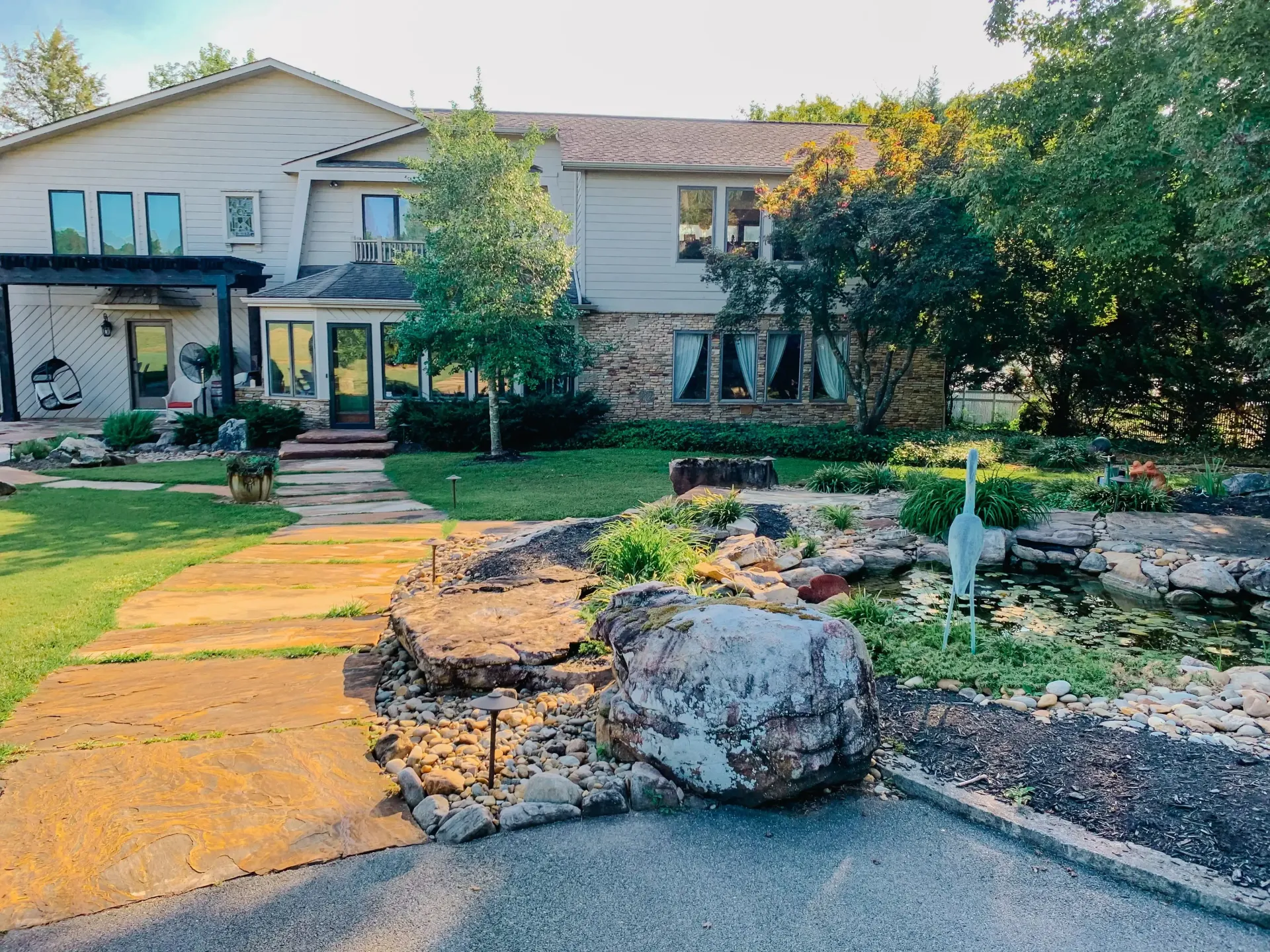 A large white house with a large rock in front of it.