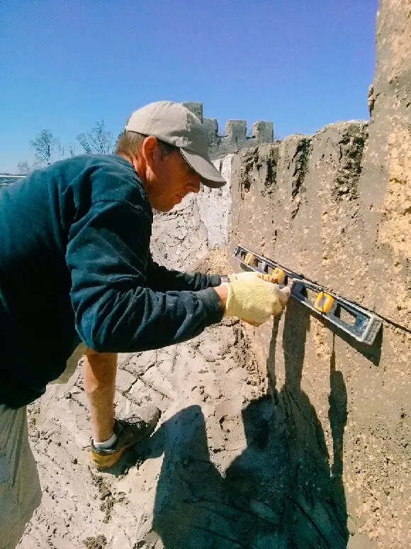 A man is measuring a wall with a level