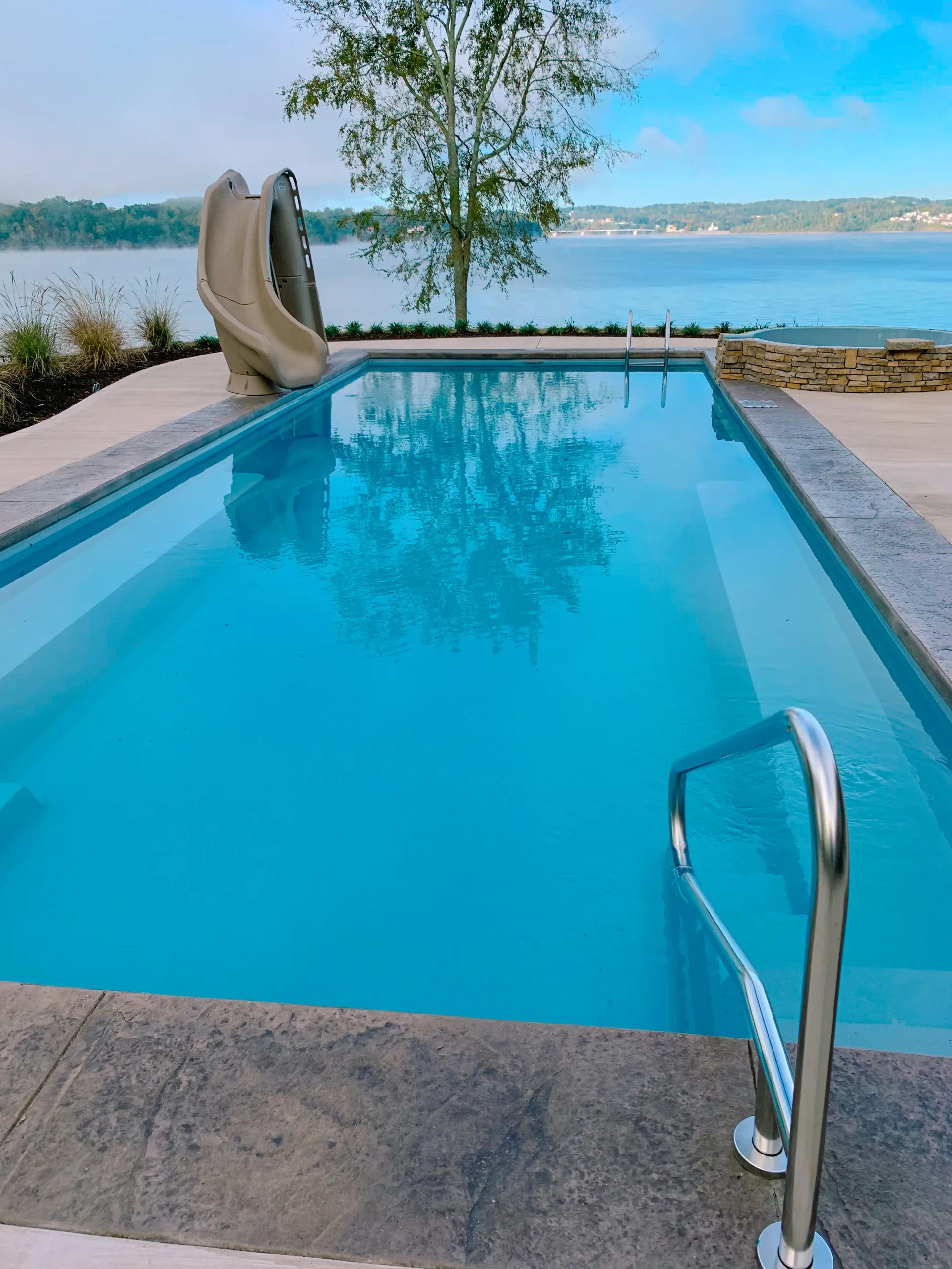 A large swimming pool with a slide in the background