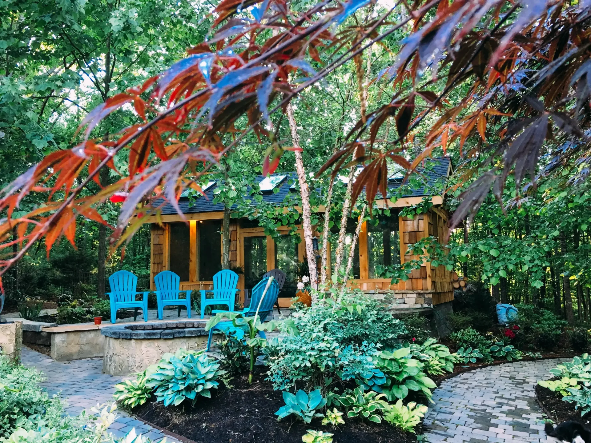 A garden with blue chairs and a gazebo in the background.