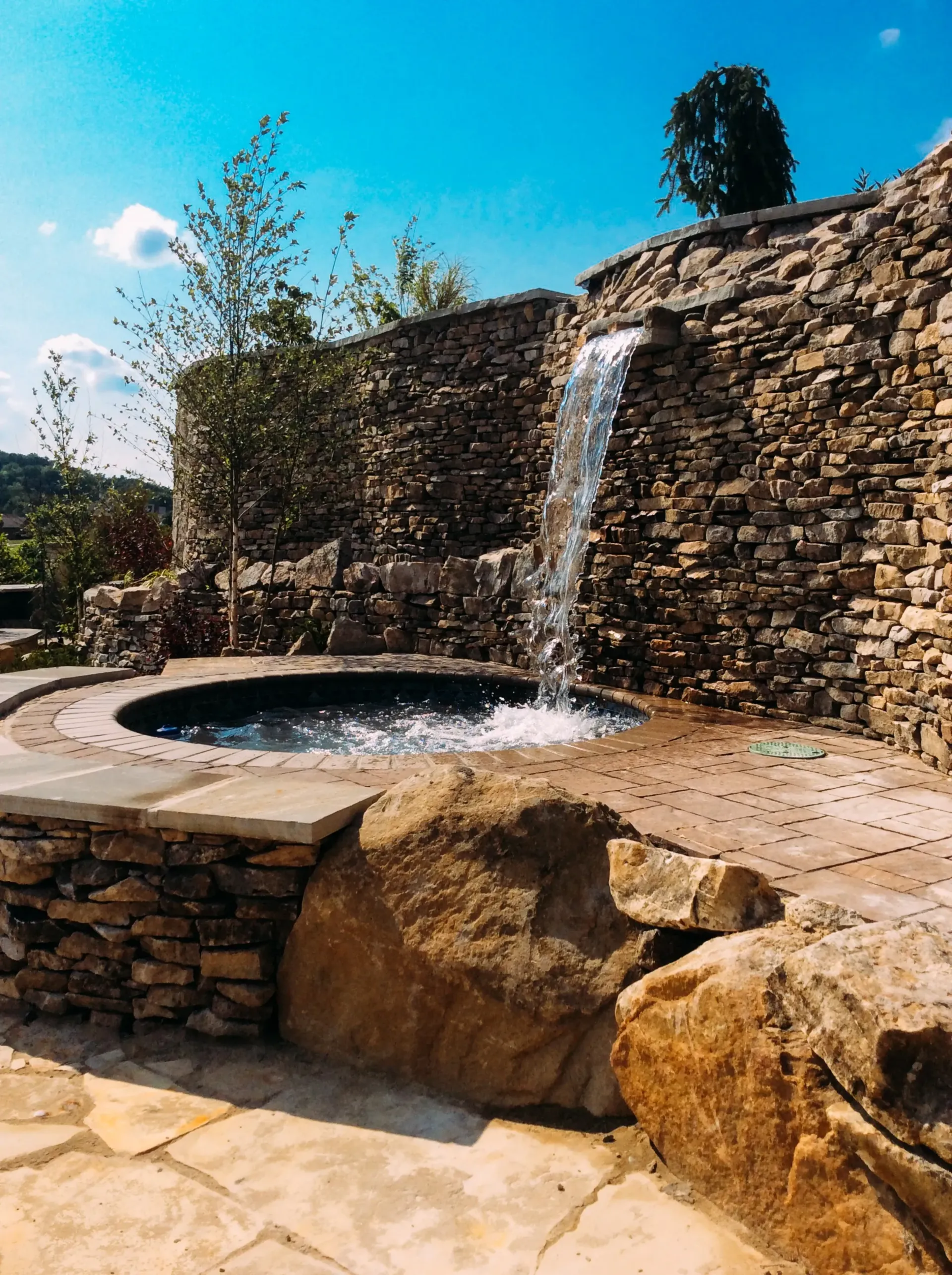 There is a waterfall in the middle of a stone wall.
