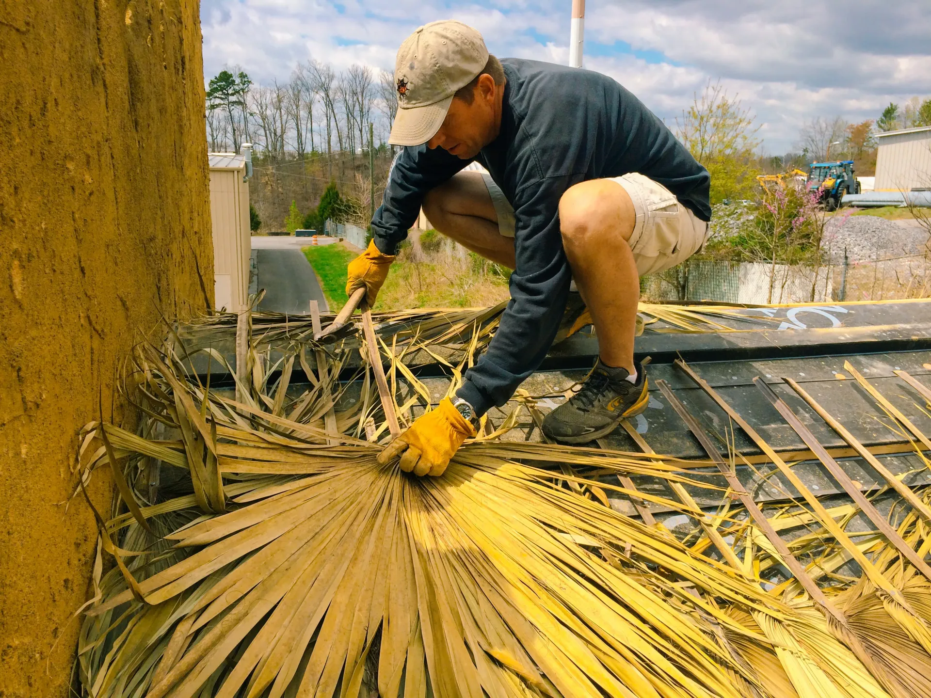 A man is working on a roof with a hammer.