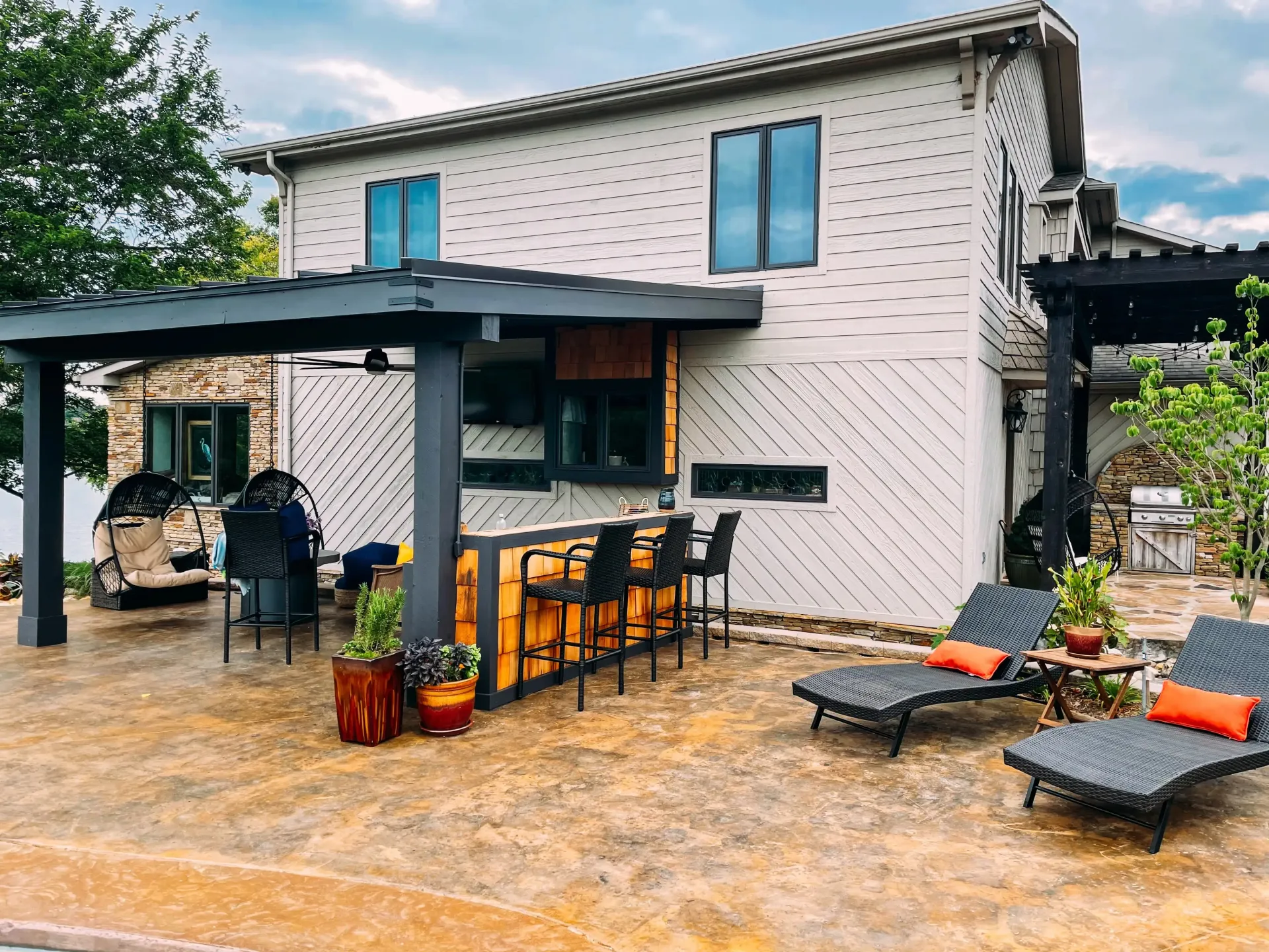 A large white house with a patio area and a pergola.