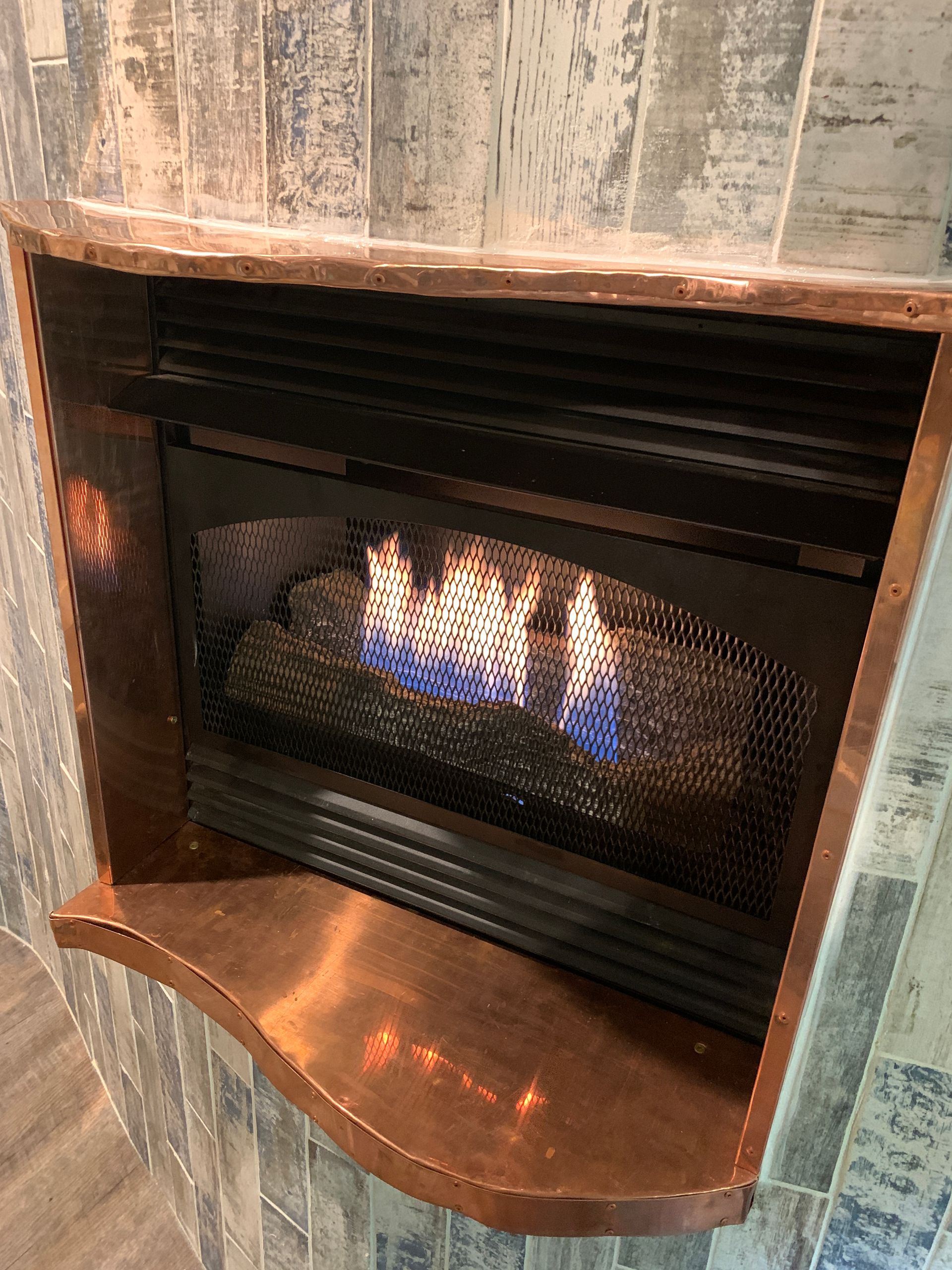 Close-up view of fireplace flame inside custom-built she shed
