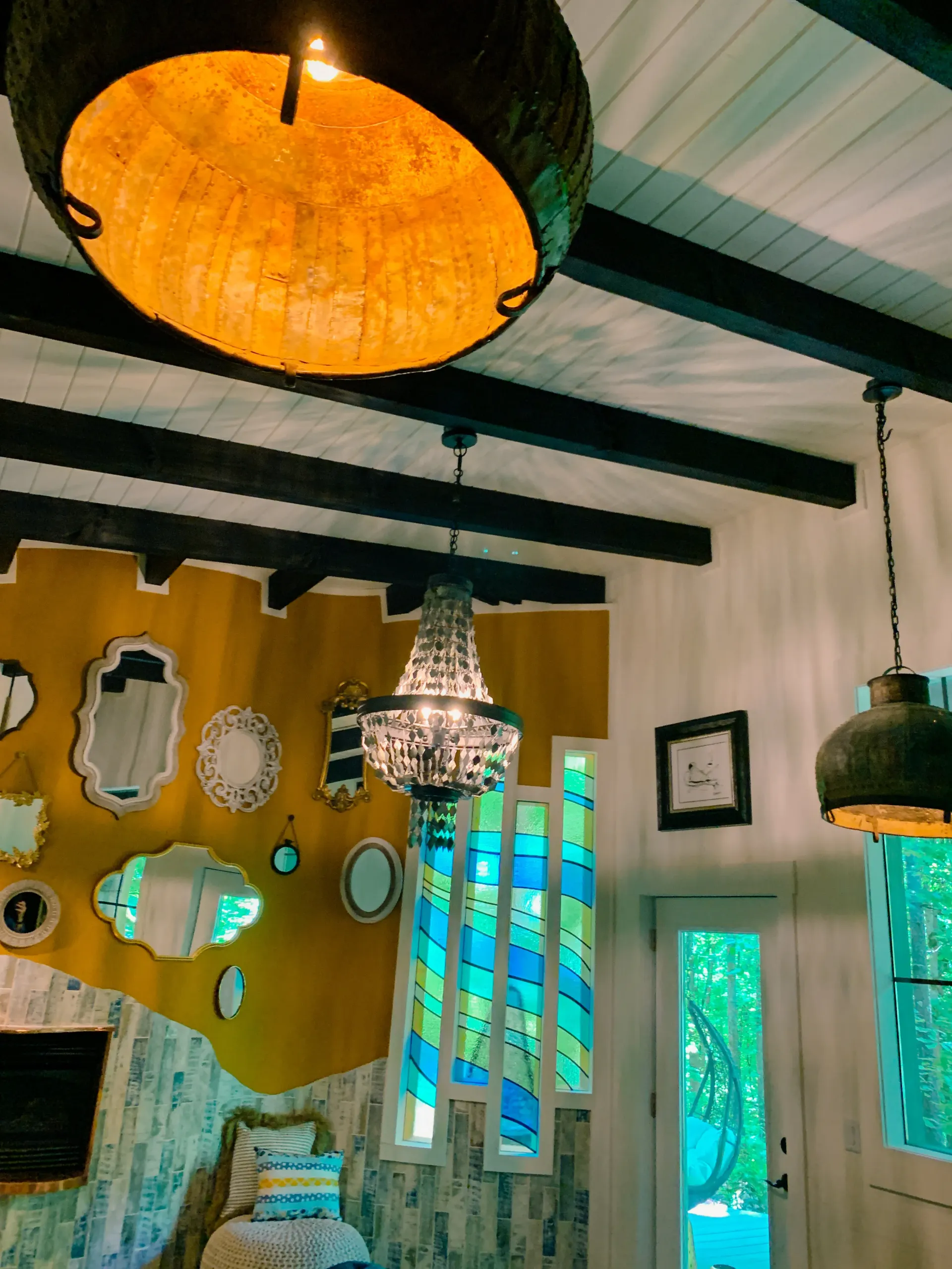 Vaulted ceiling with exposed black beams and statement light fixtures