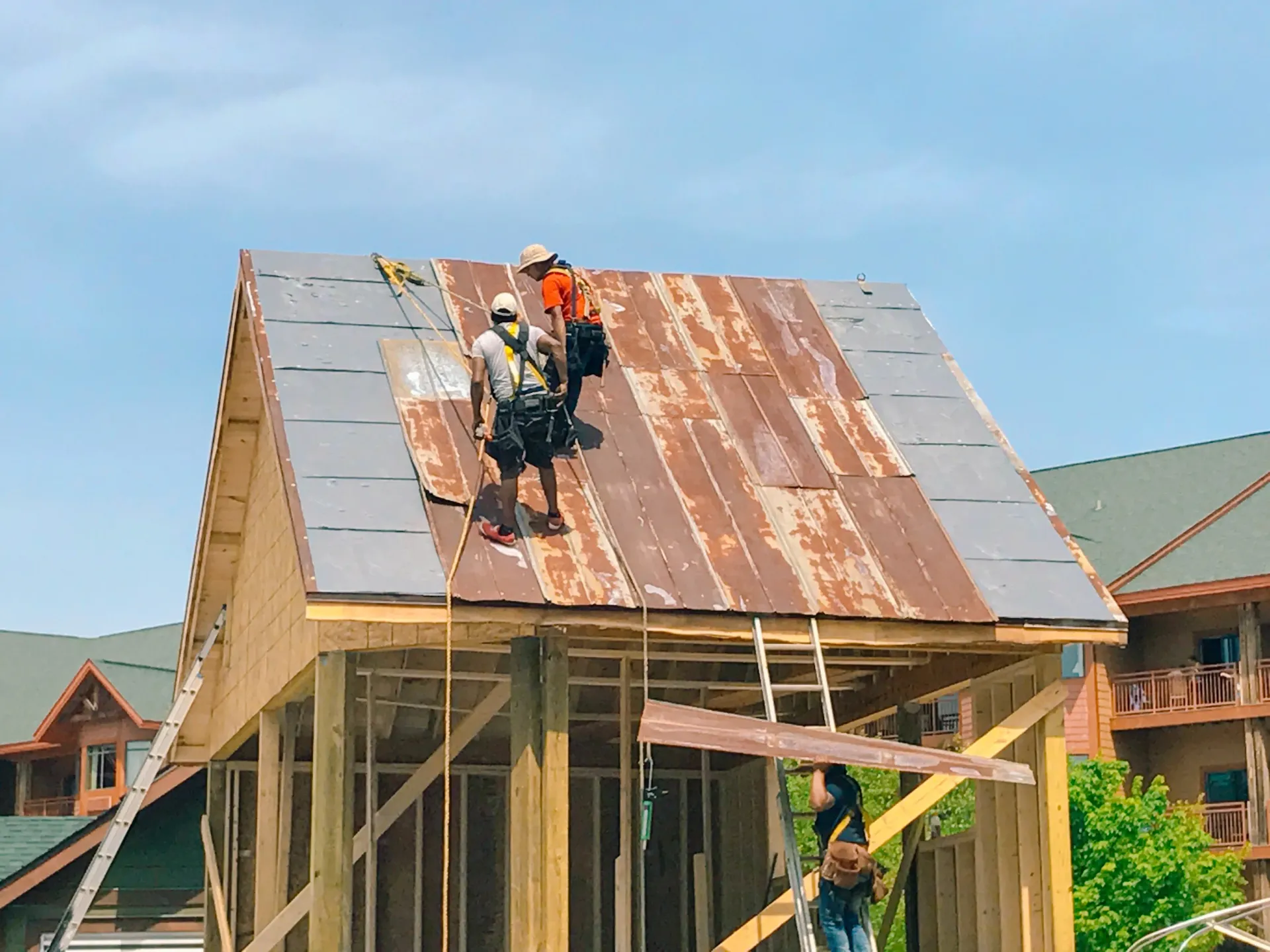 A group of construction workers are working on the roof of a building.