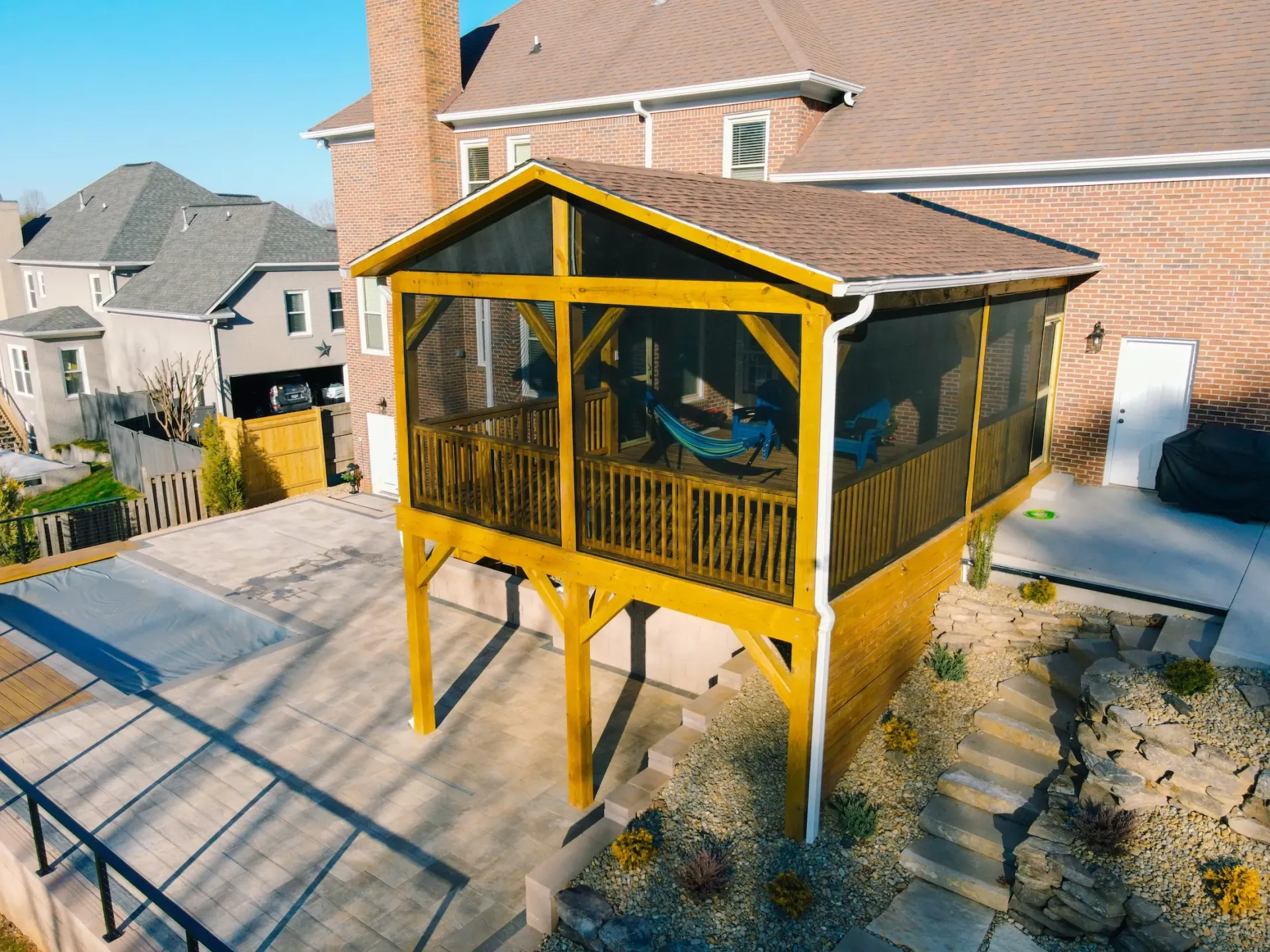 Custom-built sunroom with cedar shake siding and full wall of screened windows