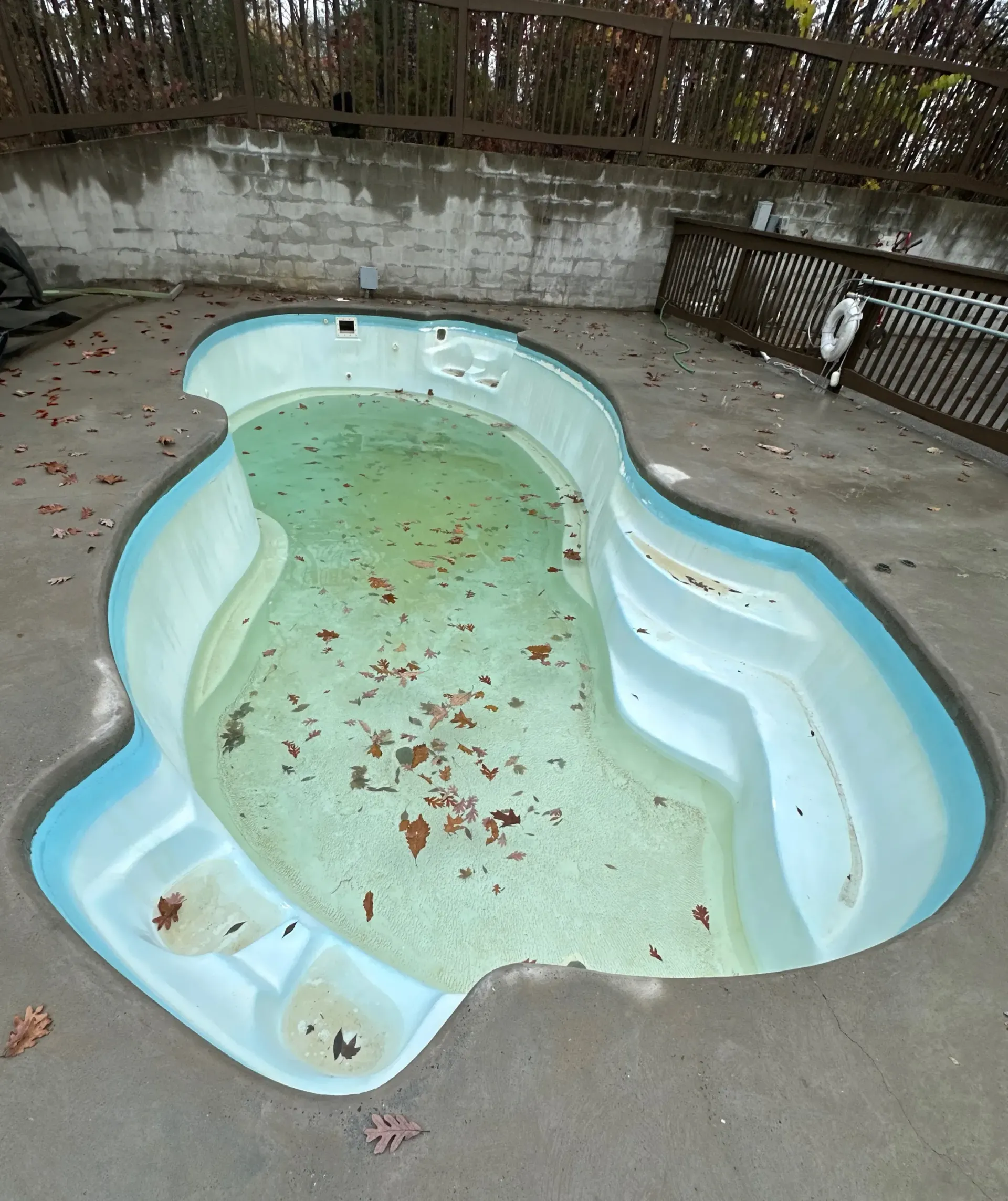 A large swimming pool is being built on the deck of a house.
