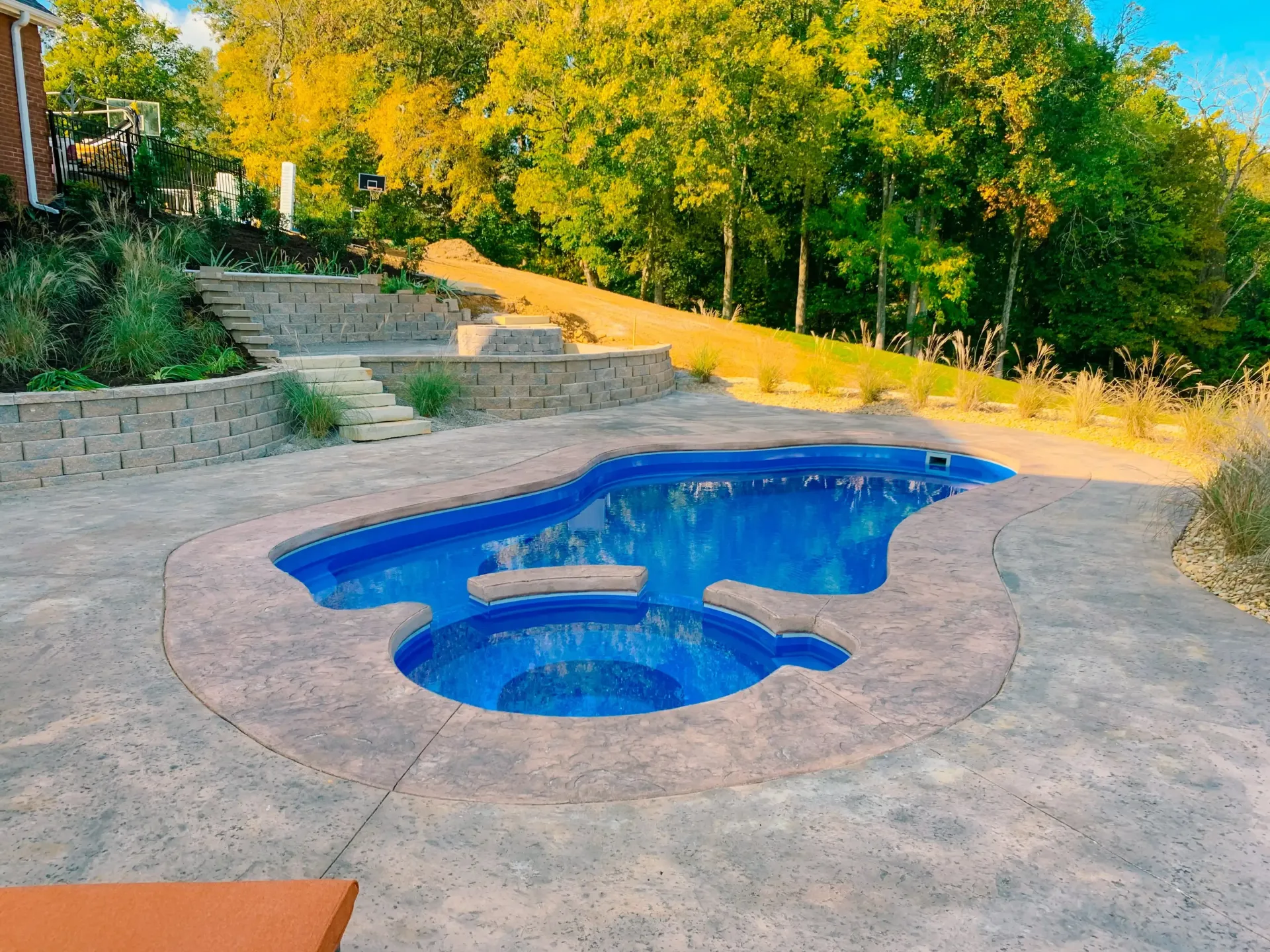 A swimming pool with a hot tub in the middle of it