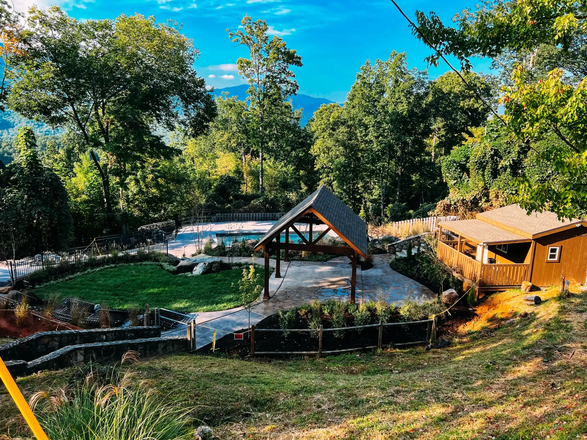 There is a house in the middle of a lush green field surrounded by trees.