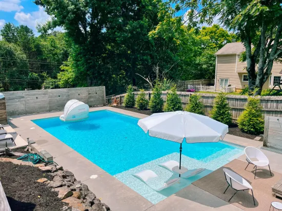 A large swimming pool with umbrellas and chairs around it
