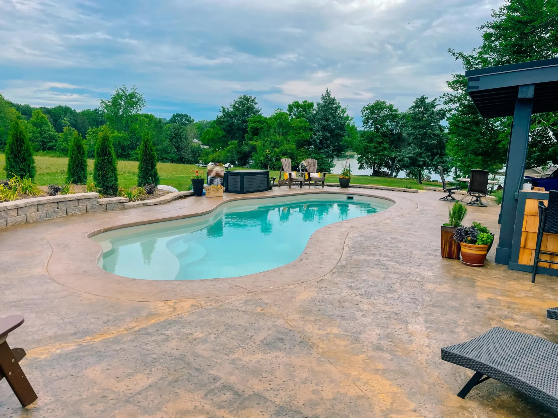 There is a large swimming pool in the middle of the backyard.