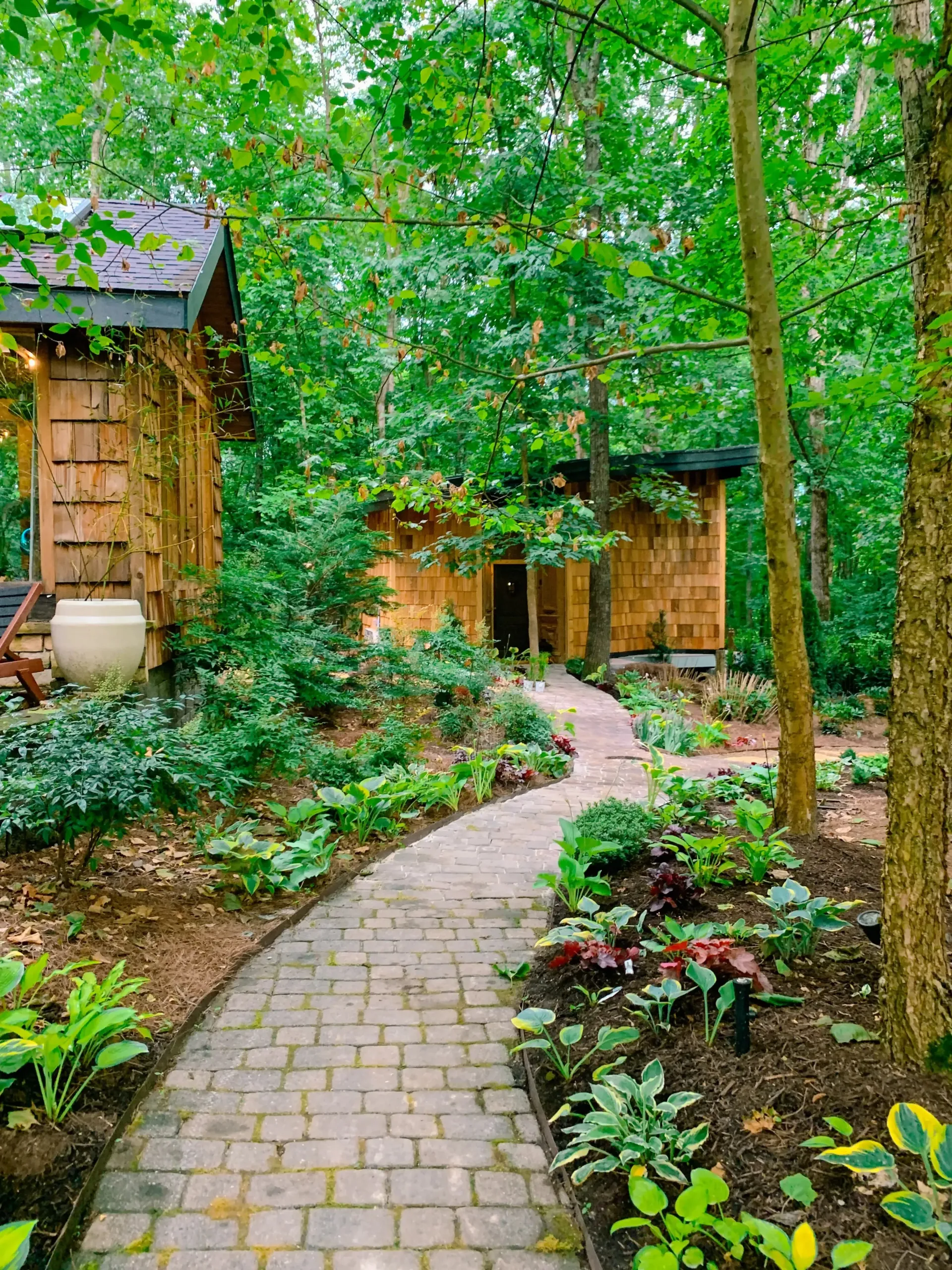 A brick walkway leading to a she shed in the woods in east tennesee