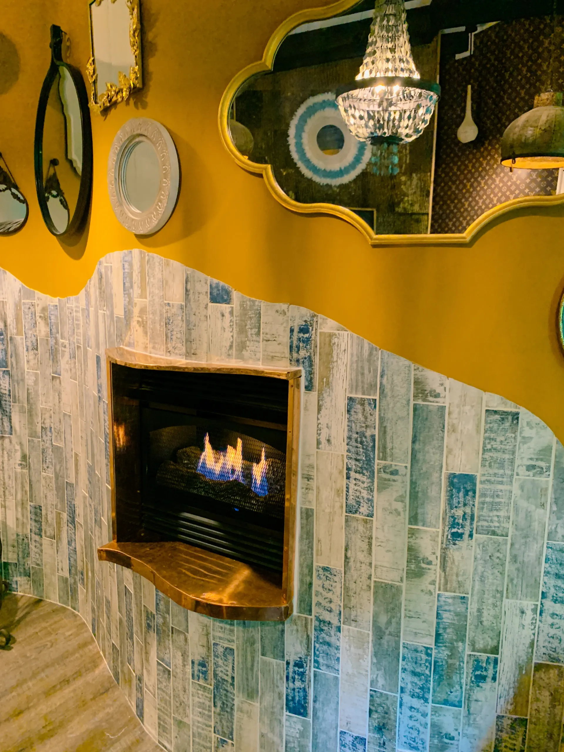 A room with a fireplace and mirrors on the wall