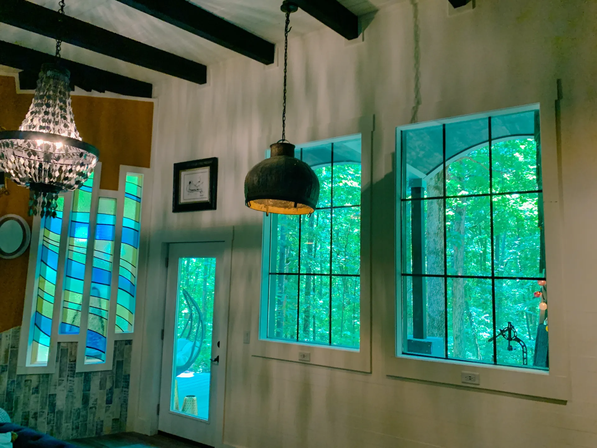 A room with a lot of windows and a chandelier hanging from the ceiling