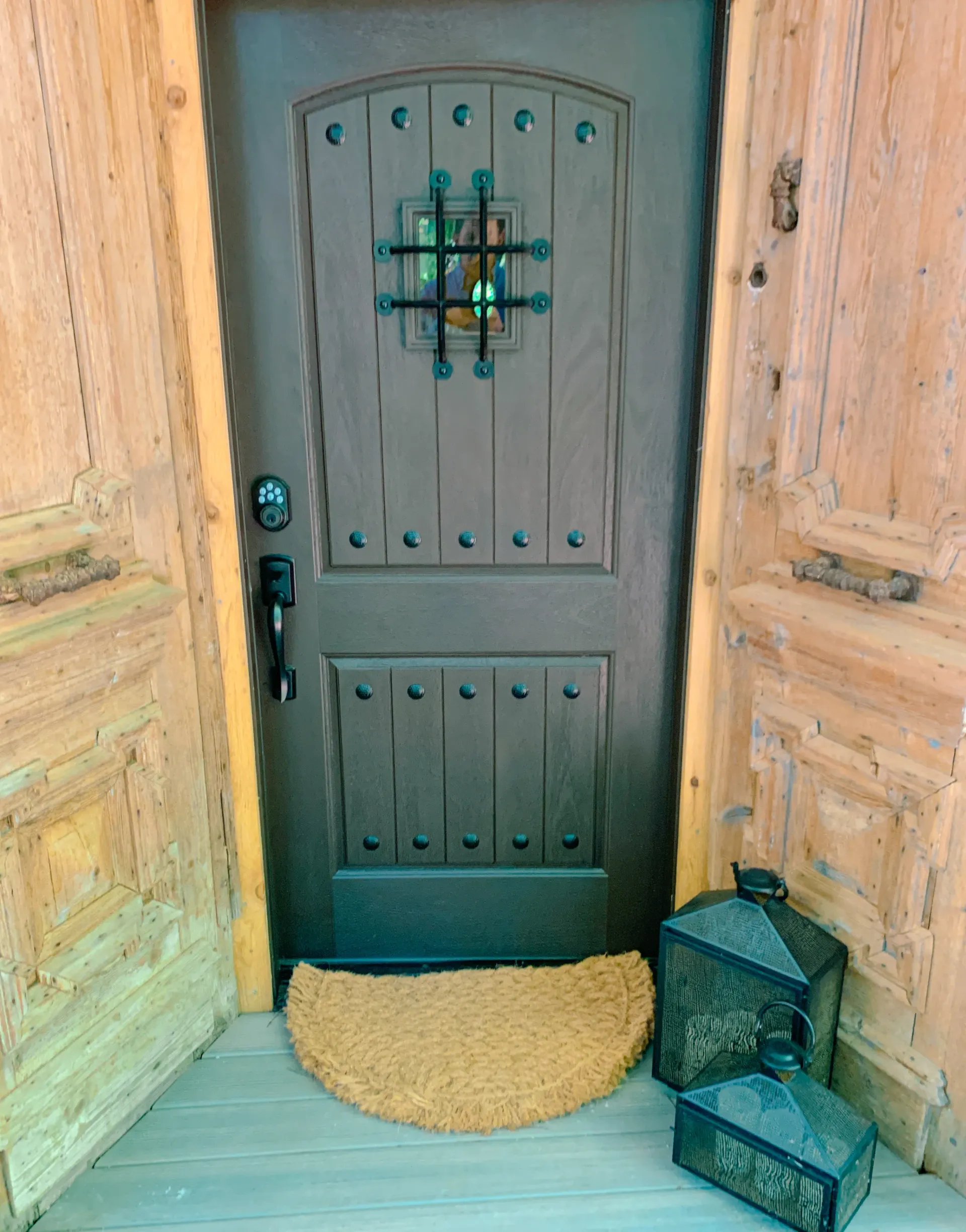 A door with a doormat and lanterns in front of it