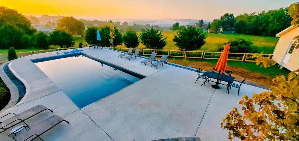 An aerial view of a large swimming pool surrounded by chairs and umbrellas.