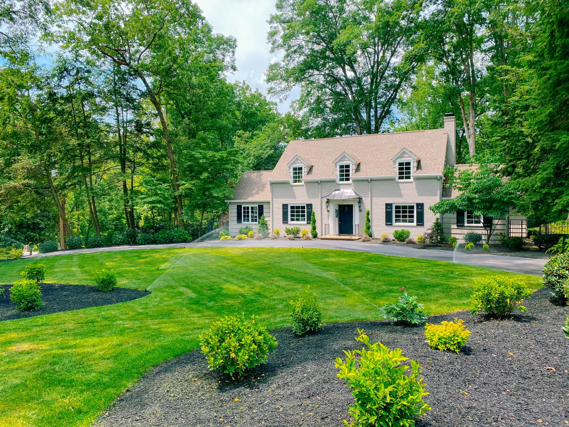 A sprinkler is spraying water on a lush green lawn in east tennessee installed by sunshien outdoor living 