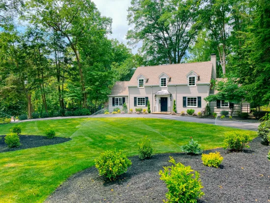 A lawn sprinkler is spraying water on a lush green lawn.