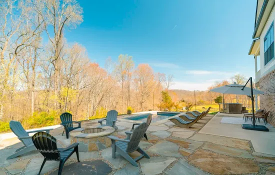 Expansive flagstone patio with custom fire pit, lounge seating, and scenic mountain views