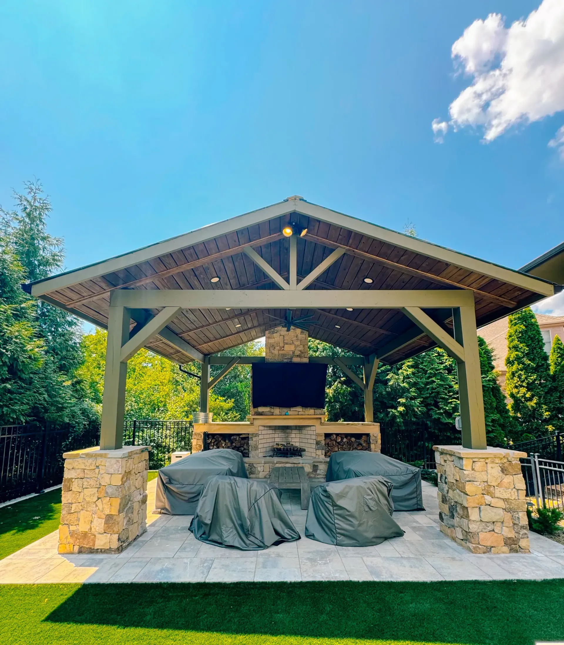 A large outdoor pavilion with a television and a fireplace
