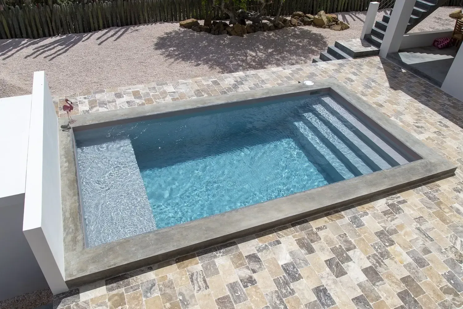 A small swimming pool with stairs leading to it