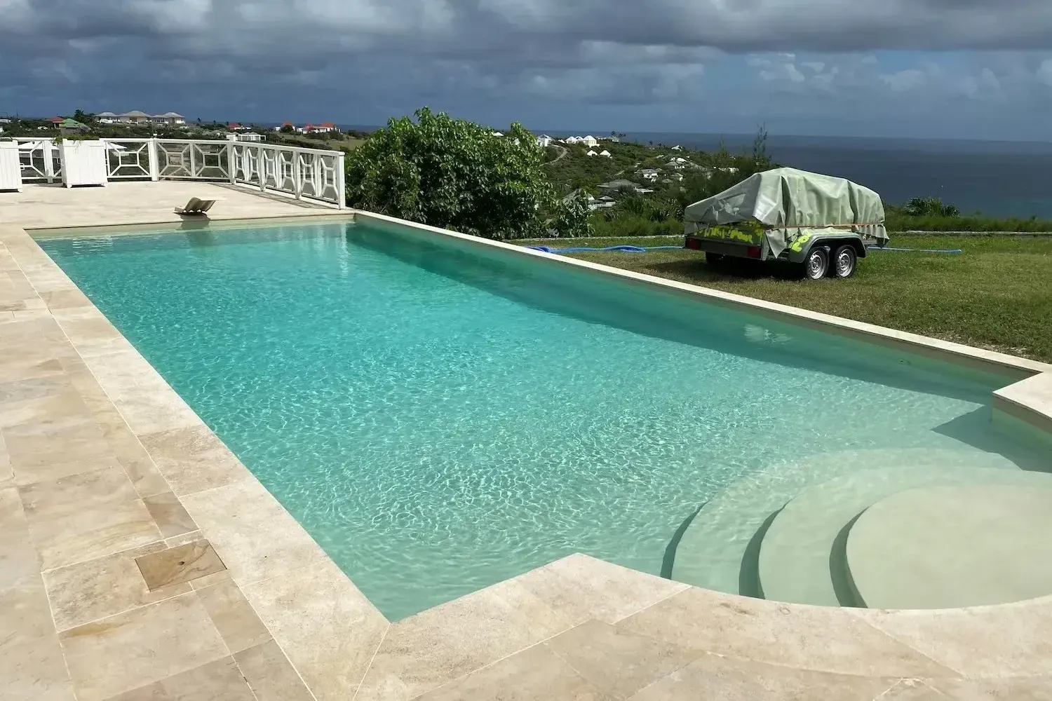 A large swimming pool with a boat in the background