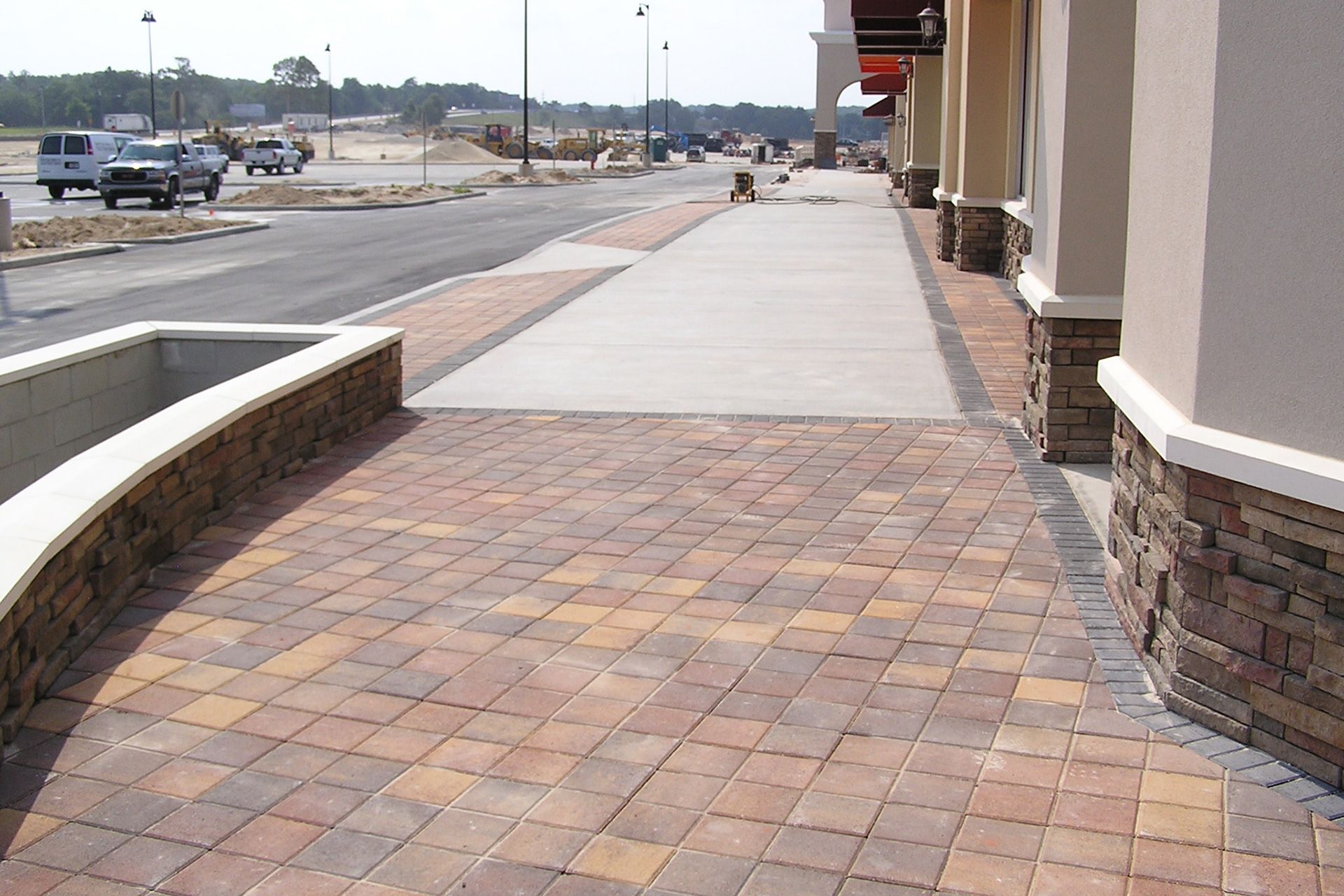A sidewalk with bricks along the side of a building
