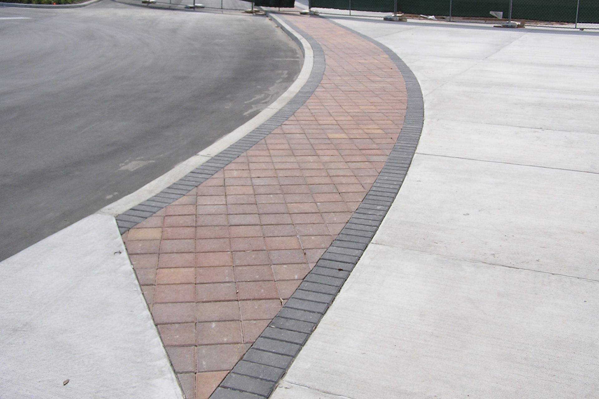 A brick walkway along the side of a road